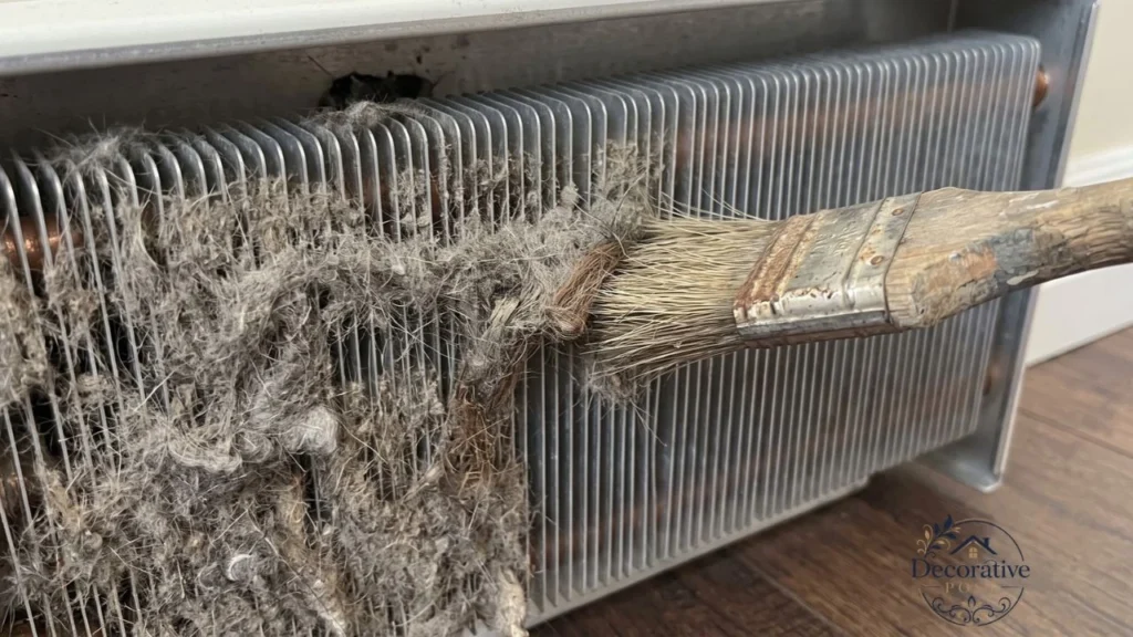 Matted pet hair packed between baseboard heater fins